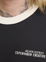 Remera negra de manga corta y cuello redondo, con fit oversize y largo cropped. Presenta un estampado frontal con la palabra "Originals" en blanco y detalles de texto y el número "1990". El cuello y los puños son de color beige.