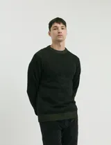Sweater de punto con cuello redondo, manga larga y puños y ruedo acanalados. Presenta un diseño jaspeado en tonos oscuros.