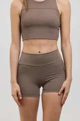 Minishort deportivo de tiro alto con bolsillos laterales, confeccionado en tejido elastizado de compresión media.