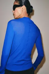 Camiseta de algodón negro de corte slim fit, con cuello subido, manga larga y cierre frontal de botones pequeños.