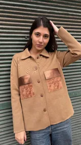 Camisa color beige tejida en lana con bolsillos de cuero color cobre.