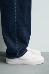 Zapatillas deportivas de cordones, color blanco, con suela gruesa.