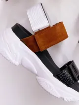 Sandalias con plataforma blanca y tiras de cuero en color negro, blanco y marrón. Las tiras tienen diferentes texturas: cuero liso, cuero con textura de cocodrilo y gamuza.