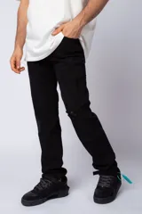 Jean de corte recto y estilo relaxed fit, color negro, con detalles de roturas y desgaste en las rodillas.