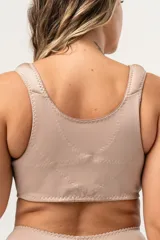Top blanco corrector de postura y de uso post operatorio, con breteles anchos acolchados, ganchos delanteros reforzados con dos tensiones y bandas cruzadas reforzadas en la espalda. Confeccionado con tela que contiene fibra LYCRA®.