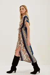 Vestido midi de viscosa con estampado étnico multicolor, escote en V, mangas cortas y ajuste con cordón en la cintura. Presenta una abertura frontal en la falda.