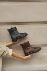 Botas cortas de cuero color marrón chocolate, con suela track negra y costuras a la vista.