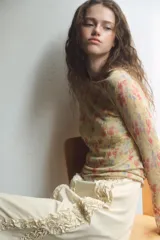 Top de punto fino con estampado floral, cuello redondo y manga larga.