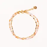 Pulsera doble de acero enchapado en oro, con una cadena de eslabones planos y otra de cuentas facetadas en tonos pastel. Cuenta con cierre de mosquetón y cadena de extensión.