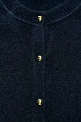 Chaqueta de punto de tacto suave en color azul marino, con cuello redondo, manga larga y cierre frontal con botones dorados.