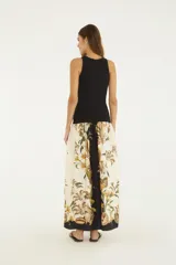 Vestido largo Farm Rio de corte recto, con cuerpo negro tipo musculosa con estampado gráfico frontal y falda fluida en color crudo con estampado botánico y marino de flores y caracoles.