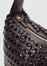Bolso de hombro mediano en color marrón oscuro, con diseño trenzado texturizado, asa ajustable y cierre superior de cremallera.