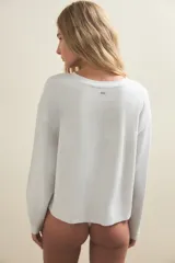 Remera de manga larga con cuello redondo, confeccionada en una mezcla suave de algodón y modal. Presenta un diseño básico y versátil con un corte holgado y cómodo.