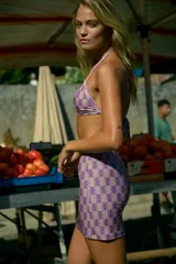Falda corta de tiro medio-alto con corte recto, confeccionada en lycra estampada con monograma de la marca en color violeta sobre fondo rosado.