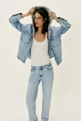 Cazadora de denim oversize con capucha gris desmontable, cuello camisero, cierre frontal con botones metálicos y bolsillos delanteros de plastrón.