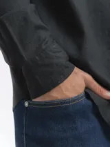 Camisa de manga larga, color blanco, con cuello camisero y botones frontales. El tejido presenta una textura visible de lino.