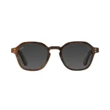 Lentes de sol con armazón de madera con acabado veteado y cristales oscuros. Presentan un diseño de marco redondeado con detalles metálicos en las esquinas.