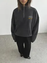 Buzo tipo half zip de algodón con efecto acid wash, cuello alto con cierre, mangas largas y puños y cintura de rib. Presenta un gran estampado en la espalda con diseño de calavera y texto.