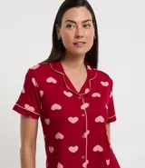 Pijama americano corto de dos piezas en viscolycra con estampado de corazones. Incluye blusa de manga corta con cuello, cierre frontal con botones y short con cintura elástica.