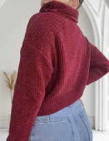 Sweater de punto grueso color bordó, con cuello alto y mangas largas.