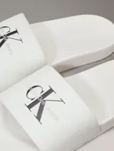 Ojotas blancas de Calvin Klein Jeans, con capellada de lona con logo estampado en negro.