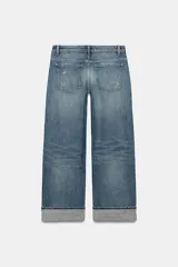 Jeans de mezclilla de tiro bajo y corte recto, con diseño de cinco bolsillos, trabillas para cinturón y dobladillo con vuelta ancha. Presenta un lavado azul medio con efecto desgastado.