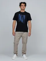 Remera de cuello redondo y manga corta, confeccionada en algodón. Presenta un estampado gráfico lineal en color azul que representa un paisaje urbano con edificios y el logo de la marca.