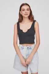 Musculosa corta gris oscuro de algodón con escote en U y terminación ondulada en el ruedo.