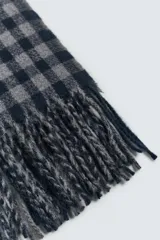 Bufanda de tejido suave con diseño de cuadros vichy en tonos gris y azul marino, terminada con flecos en los extremos.
