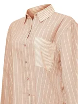 Blusa de lino y algodón orgánico en color beige con diseño de rayas verticales claras, cuello camisero, mangas largas con puños abotonados, cierre frontal con botones y un bolsillo aplicado en el pecho.