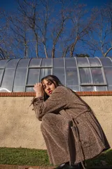 Chaqueta de crepé elastizado de lurex oro viejo, con corte clásico y cierre frontal con botones.