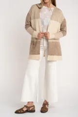 Cardigan abierto de punto con diseño de bloques de color en tonos beige, marrón y bordó. Presenta mangas largas, corte recto y bolsillos frontales aplicados.