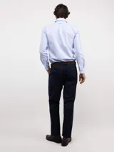 Camisa de manga larga con diseño de rayas verticales finas en color celeste y blanco. Presenta cuello clásico, cierre frontal con botones y logo bordado en el pecho.