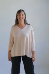 Sweater de punto en color crudo, con escote en V, mangas tres cuartos con puños acanalados y diseño holgado.