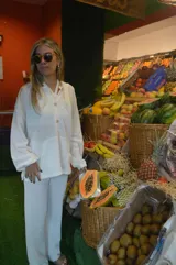 Canguro blanco de tejido waffle con capucha, cierre parcial con botones de madera y bolsillo tipo canguro.