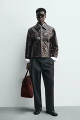 Bolso de mano marrón oscuro de cuero gamuzado, con cierre de solapa imantada y doble asa corta.