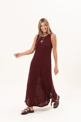 Vestido largo de tejido calado color bordó, de silueta recta, escote redondo y sin mangas, con aberturas laterales en el bajo.