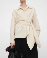 Camisa de algodón color beige, de línea semientallada, con cuello italiano, manga larga y detalle cruzado con lazo para anudar en el lateral.