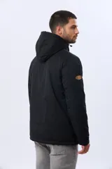 Campera puffer reversible para hombre, de color negro, con diseño capitonado, capucha integrada y bolsillos funcionales con cierre frontal.