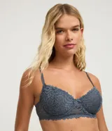 Soutien de encaje floral color gris azulado, con breteles finos y ajustables, sin copa y con aro. Presenta un pequeño lazo decorativo en el centro del busto.