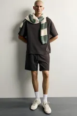 Bermuda estilo jogger de ajuste relajado, confeccionada en tejido interlock de algodón. Cuenta con cintura elástica ajustable con cordón, bolsillos frontales de vivo y diseño liso.