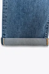 Jeans de tiro alto con corte relajado y pernera recta. Presentan diseño de cinco bolsillos, cierre frontal con cremallera y botón, y terminación con dobladillo en la parte inferior.