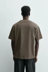 Camiseta color arena de algodón compacto, corte recto, cuello redondo y mangas cortas.