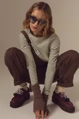 Borcego de cuero color bordó con suela de plataforma, cordones bicolores y detalle de pompones decorativos en el empeine.