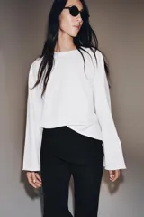 Camiseta de algodón con cuello redondo y mangas largas tipo ranglán. Presenta un corte regular y bajo recto.