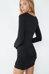 Vestido mini negro de manga larga en tejido elástico, con diseño ceñido al cuerpo y detalles cut-out en la parte superior. Lazada al cuello.
