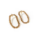 Par de aros dorados con forma ovalada, cubiertos de pequeños cristales color ámbar. Cierre con tuerca a presión.