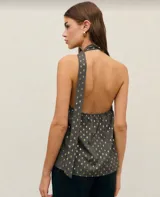 Top negro sin mangas con cuello halter y estampado de puntos dorados.