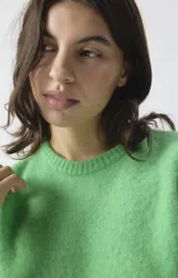 Chaleco de punto sin mangas, con cuello redondo y corte holgado. Confeccionado en tejido mullido de textura suave y compacta.