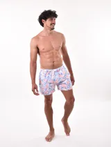 Short de baño blanco con estampado de hojas en tonos azules y rosados, cintura elástica con cordón ajustable.